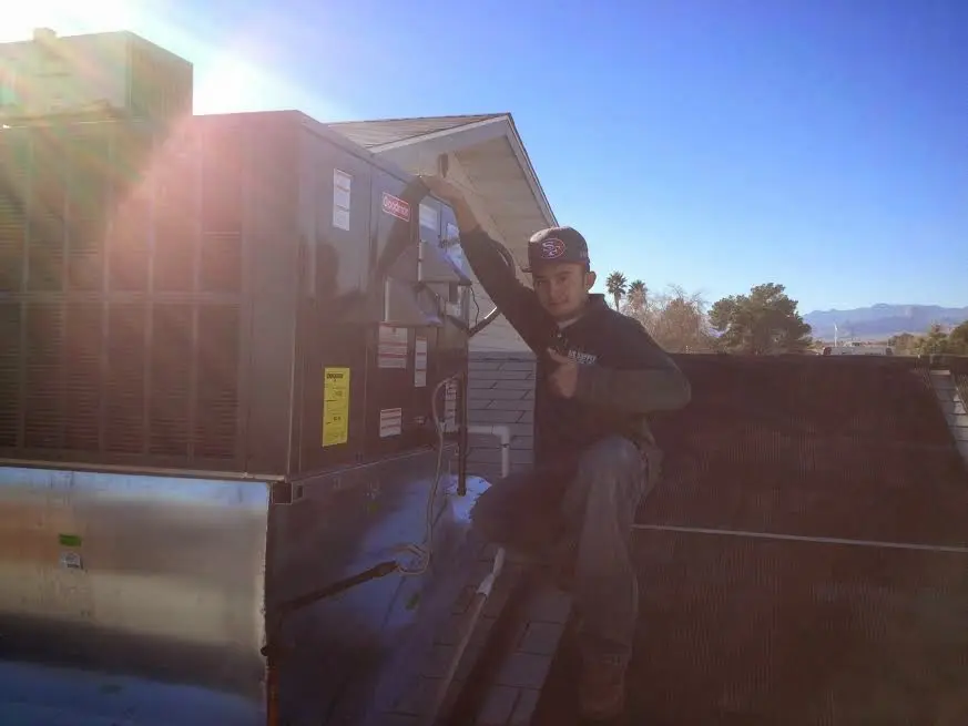 HVAC technician performing AC Tune-Up on a rooftop unit in Menifee